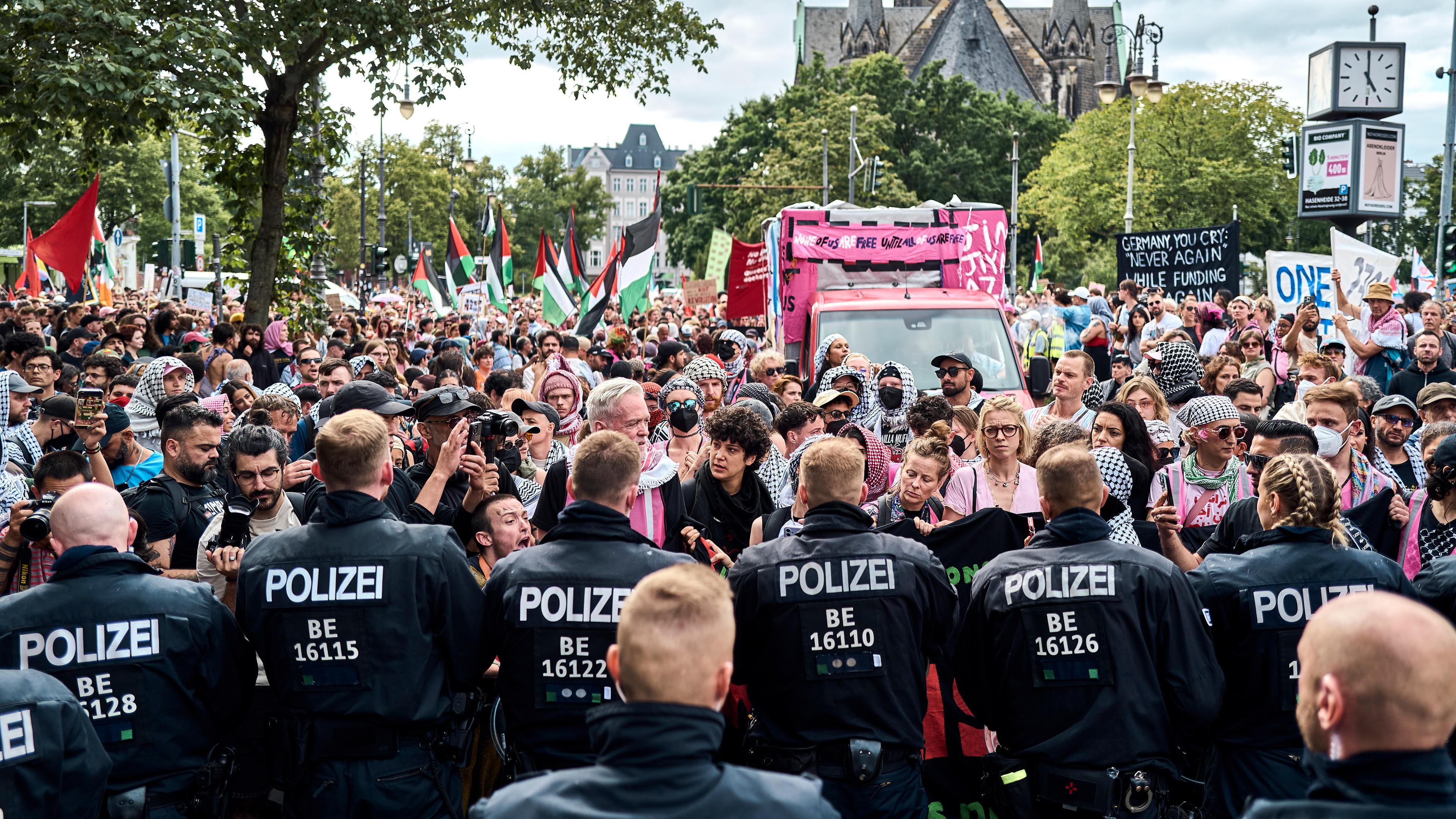 Teilnehmer der Internationalist Queer Pride for Liberation (IQP) stehen bei einer Aktion am Südstern in Kreuzberg Polizisten gegenüber.