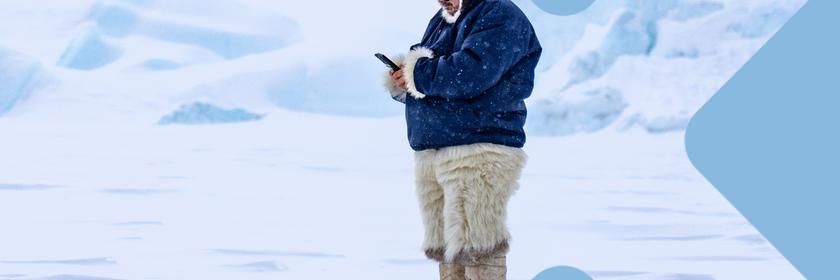 Inuit mit Smartphone in Eislandschaft