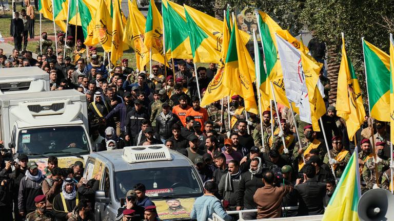 Irak, Bagdad: Mitglieder einer irakischen schiitischen militanten Gruppe nehmen an der Beerdigung eines Kämpfers der Hisbollah teil, der bei einem US-Luftangriff getötet wurde.