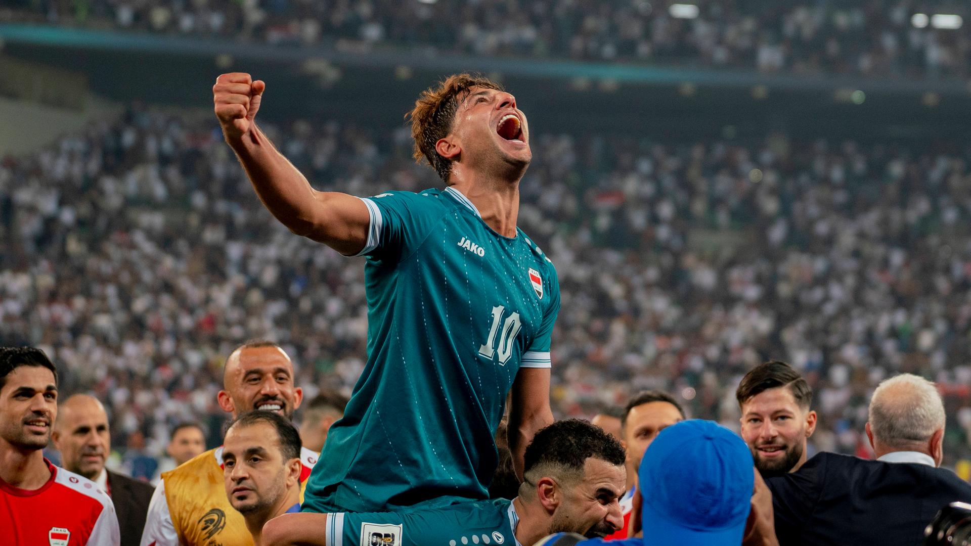 Mohanad Ali sitzt auf den Schultern seines Mitspielers Aymen Hussein und bejubelt den 2:1-Sieg im WM-Playoff-Rückspiel des Irak in Basra gegen die Vereinigten Arabischen Emirate.