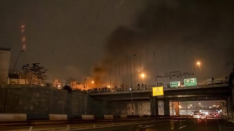 Iraner blockieren während einer Protestaktion in Teheran eine Straße.