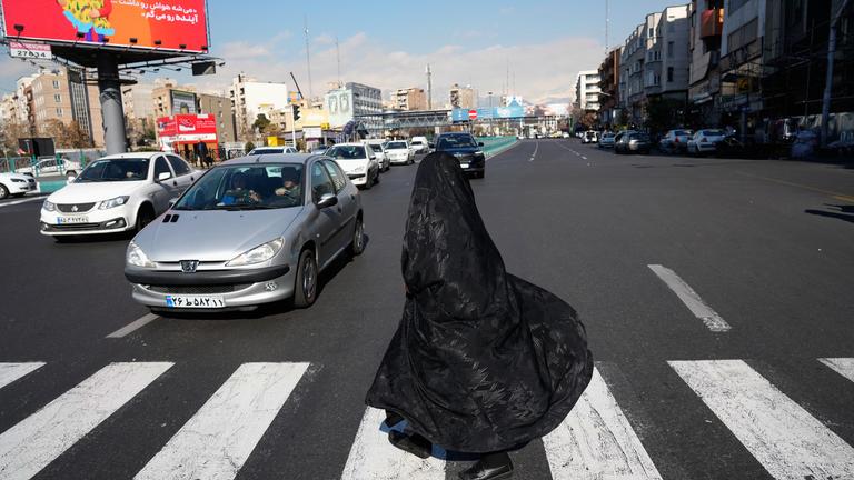 Eine Frau überquert eine Kreuzung in der Innenstadt von Teheran.