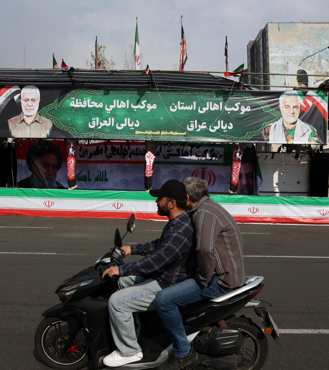 Men drive a motorcycle past billboards of Iranian Supreme Leader Ayatollah Mojtaba Khamenei (L) and his late father, former Iranian Supreme Leader Ayatollah Ali Khamenei (R), in a street in Tehran, Iran, 31 March 2026.