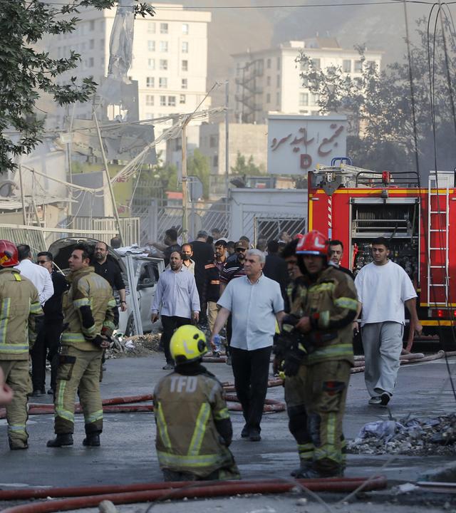 Ein Blick entlang einer Straße ein der ein beschädigtes Gebäude in der iranischen Hauptstadt Teheran nach einem Angriff am 13. Juni 2025 steht.
