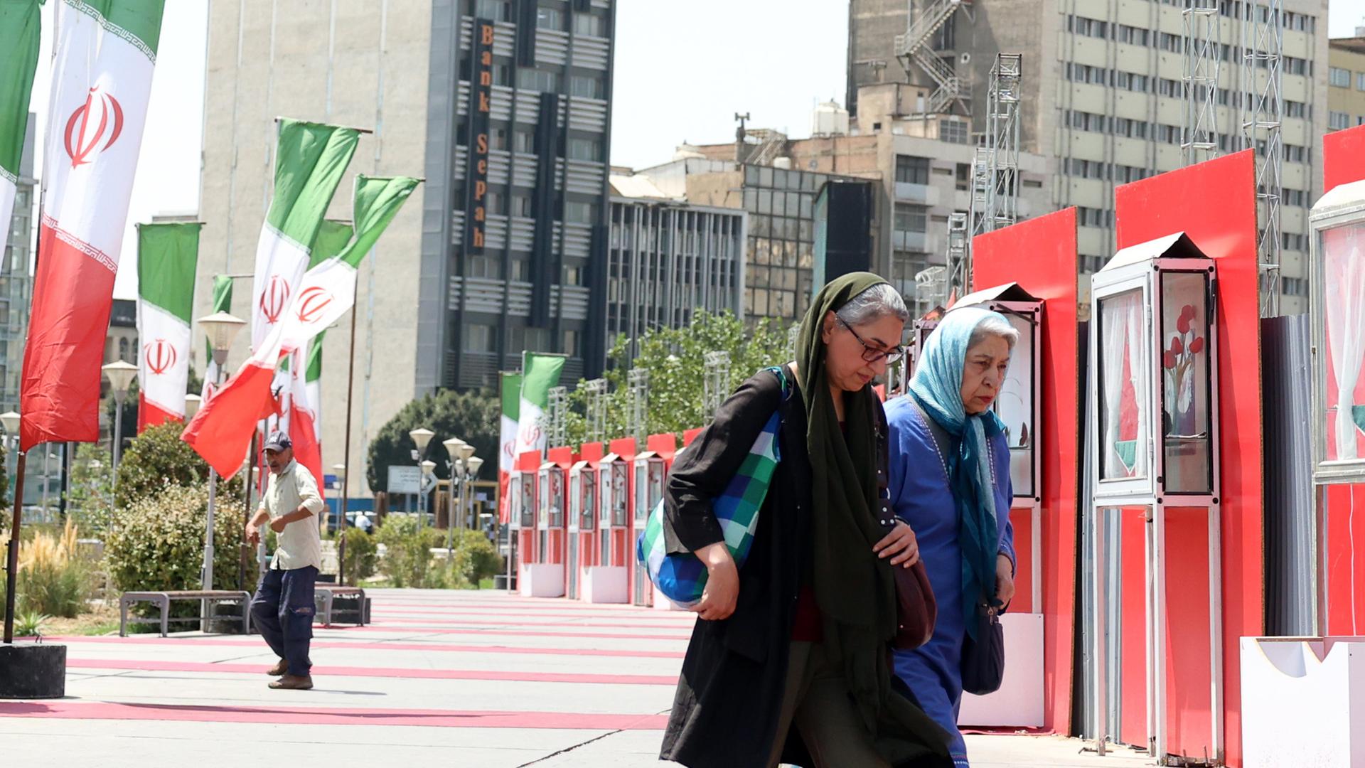 Iranerinnen laufen ein Iran Nationalbeflaggung in Teheran vorbei. Aufgenommen am 28.08.2025