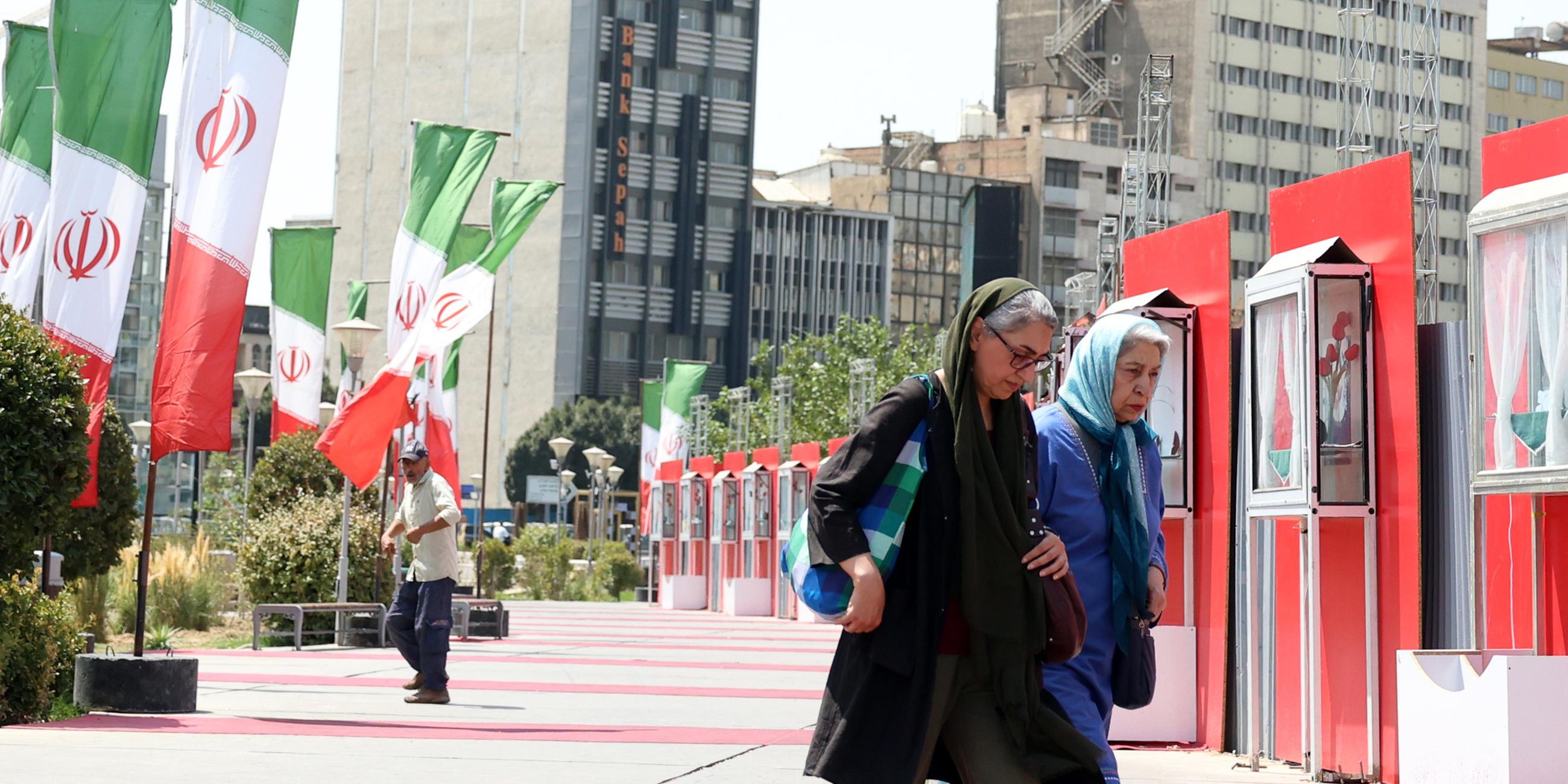 Iranerinnen laufen ein Iran Nationalbeflaggung in Teheran vorbei. Aufgenommen am 28.08.2025