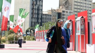 Iranerinnen laufen ein Iran Nationalbeflaggung in Teheran vorbei. Aufgenommen am 28.08.2025