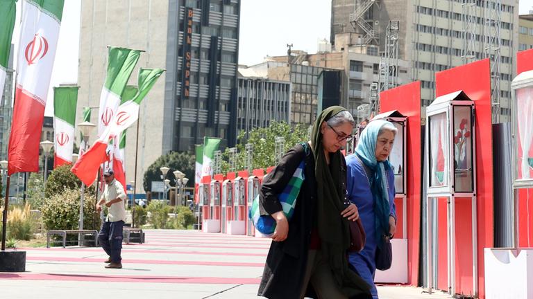 Iranerinnen laufen ein Iran Nationalbeflaggung in Teheran vorbei. Aufgenommen am 28.08.2025