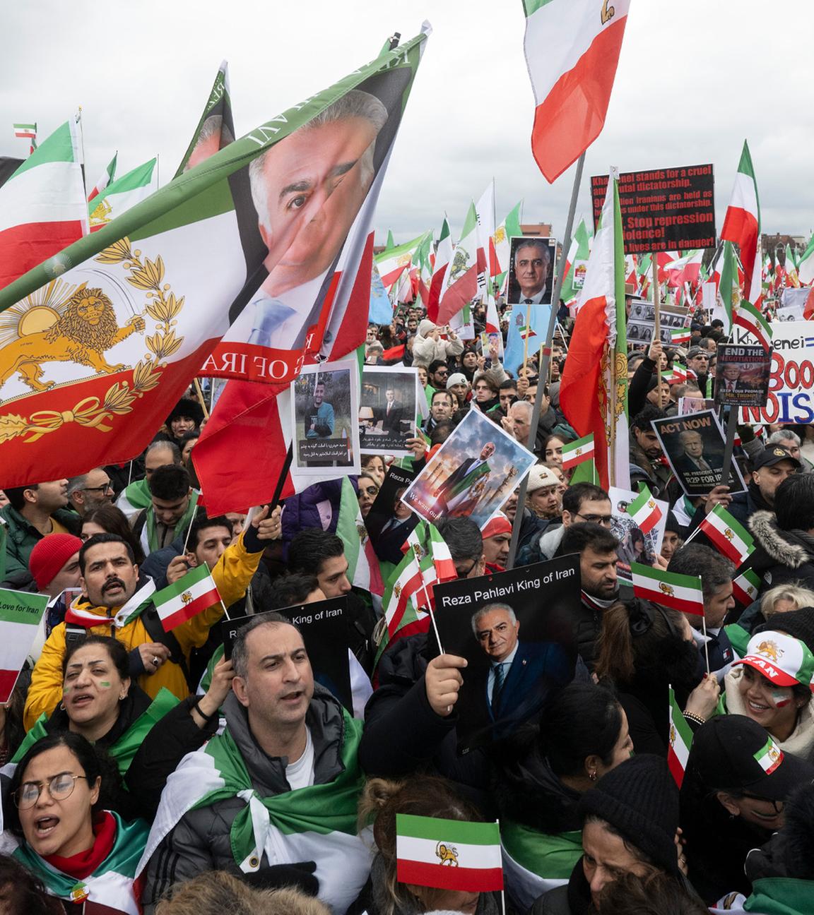 Teilnehmende einer Demonstration «Menschenrechte und Freiheit im Iran. Internationale Solidarität mit dem iranischen Volk» anlässlich der Münchner Sicherheitskonferenz stehen auf der Theresienwiese.