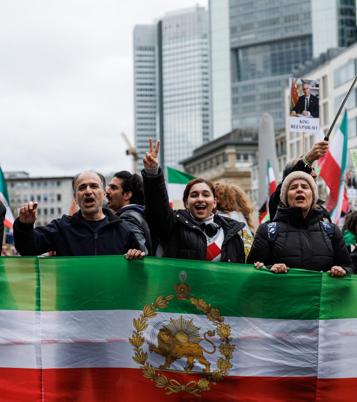  Teilnehmer halten Flaggen der iranischen Monarchie und zeigen das Victory-Zeichen auf der "Friedliche Demonstration und Aufzug für Freiheit und Demokratie im Iran" Demonstration in Frankfurt am Main.