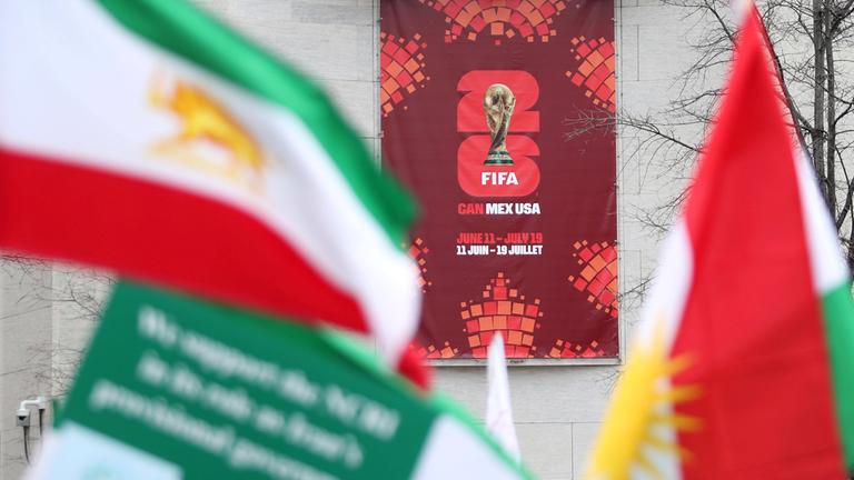 Iranische Flaggen sind neben einem Poster zur FIFA-Weltmeisterschaft 2026 während einer Demonstration gegen das iranische Regime zu sehen, Washington, D.C., Virginia, Vereinigte Staaten, 7. März 2026. (Archiv)