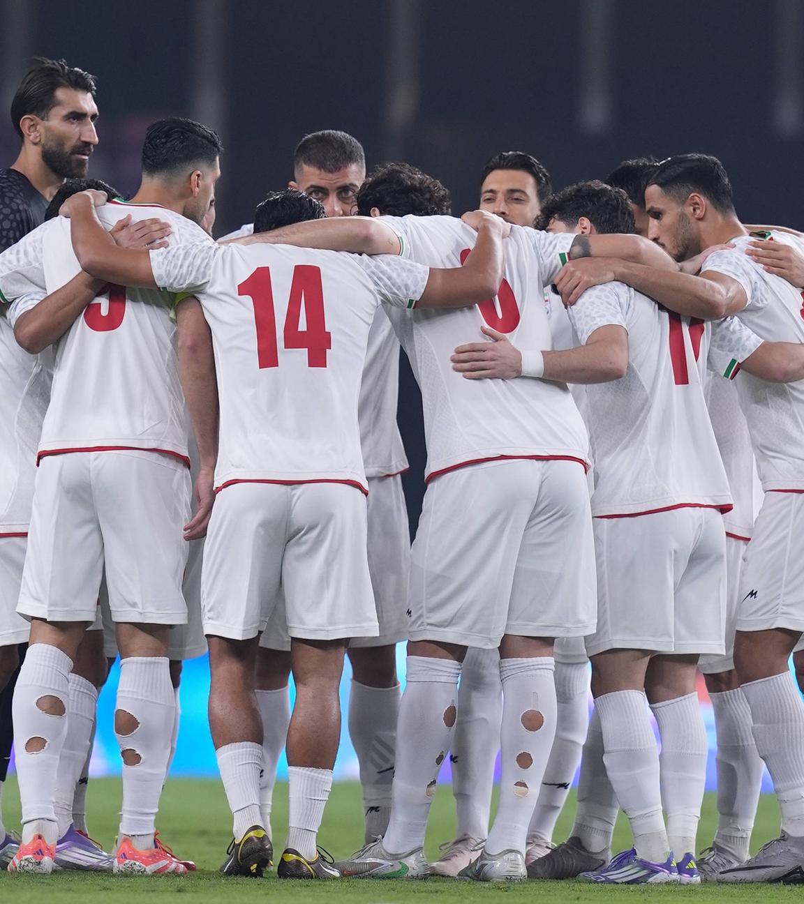 Spieler der iranischen Fußball-Nationalmannschaft bilden einen Kreis und fassen sich an die Schulter