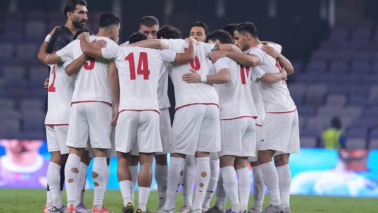 Spieler der iranischen Fußball-Nationalmannschaft bilden einen Kreis und fassen sich an die Schulter