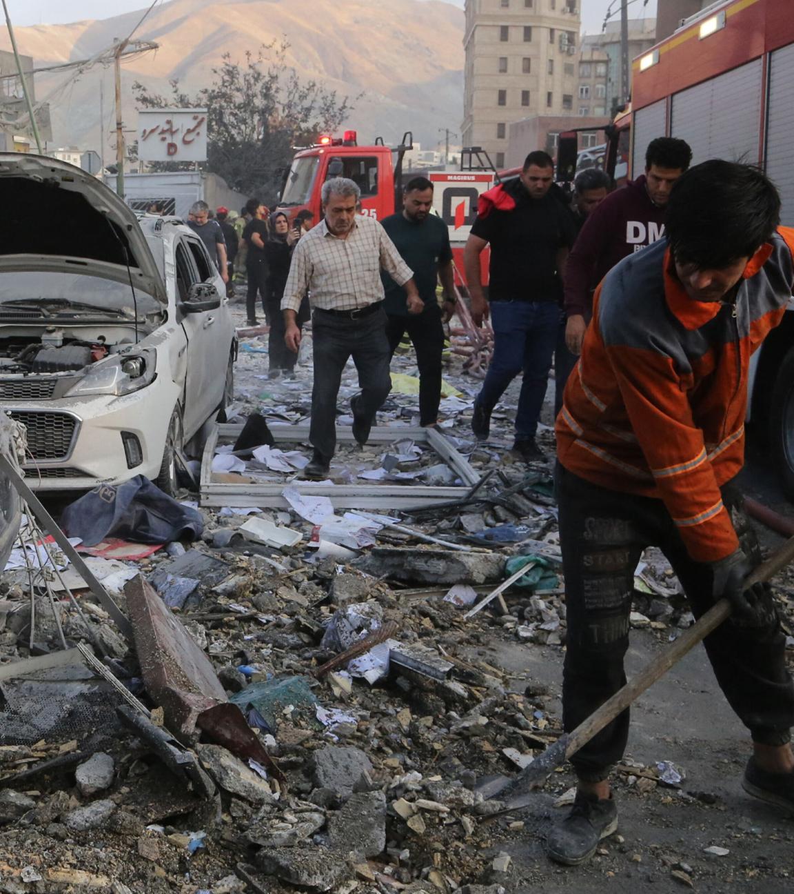 Iranische Feuerwehrleute räumen Schutt von der Straße. Nach einem Israelischen Angriff auf Teheran in der Nacht vom 13.06.2025 