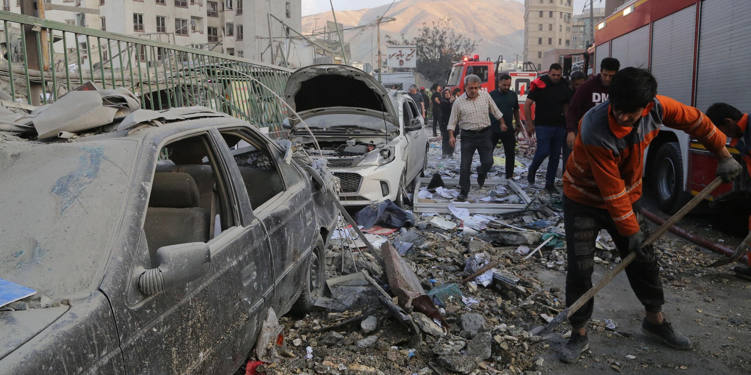 Iranische Feuerwehrleute räumen Schutt von der Straße. Nach einem Israelischen Angriff auf Teheran in der Nacht vom 13.06.2025 