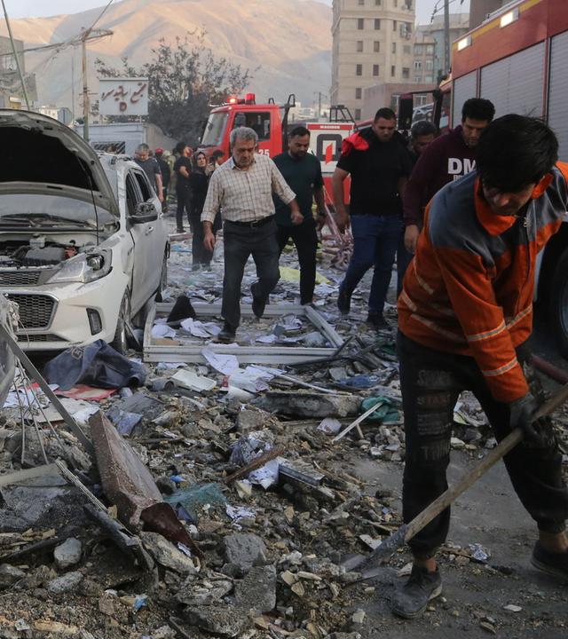 Iranische Feuerwehrleute räumen Schutt von der Straße. Nach einem Israelischen Angriff auf Teheran in der Nacht vom 13.06.2025 