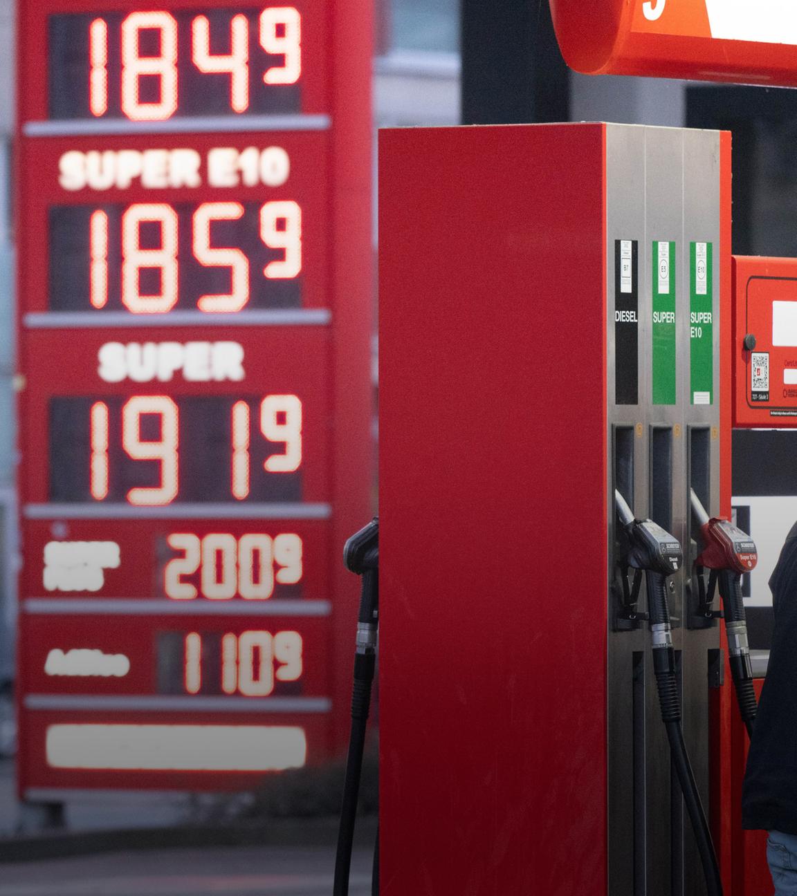 Sachsen, Dresden: Ein Mann betankt an einer Tankstelle vor einer Preistafel ein Auto.
