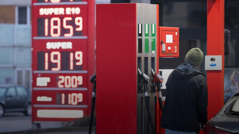Sachsen, Dresden: Ein Mann betankt an einer Tankstelle vor einer Preistafel ein Auto.