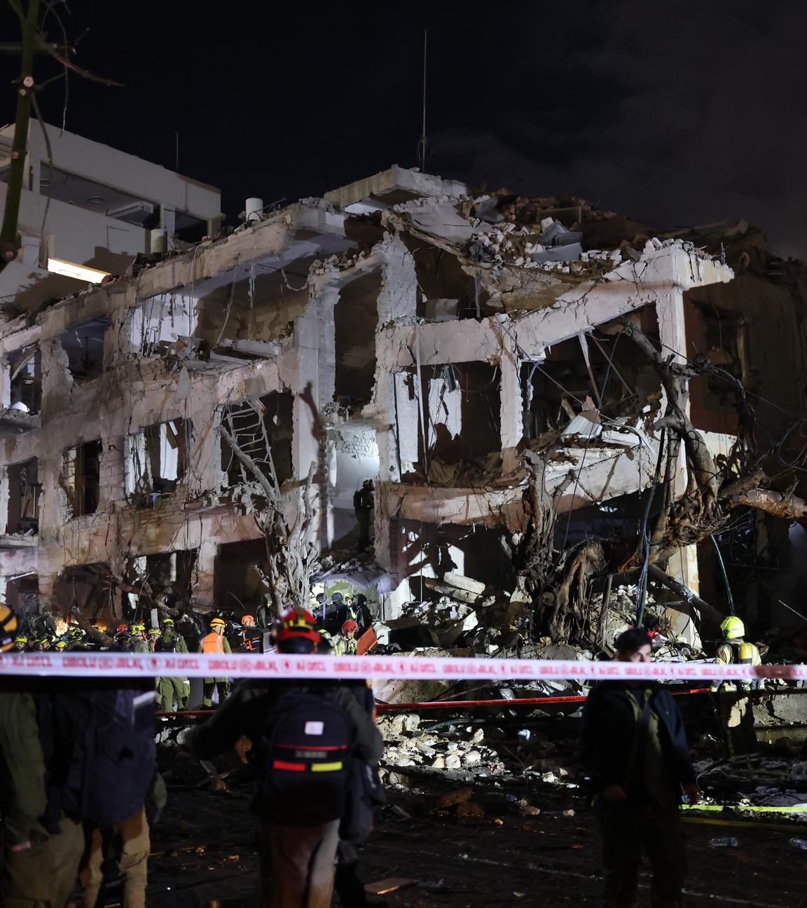 Israelische Ersthelfer treffen nachts am Schadensort in Tel Aviv ein. Ein Haus ist durch den Luftangriff zerstört worden.