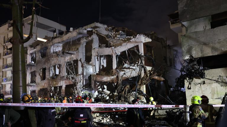 Israelische Ersthelfer treffen nachts am Schadensort in Tel Aviv ein. Ein Haus ist durch den Luftangriff zerstört worden.