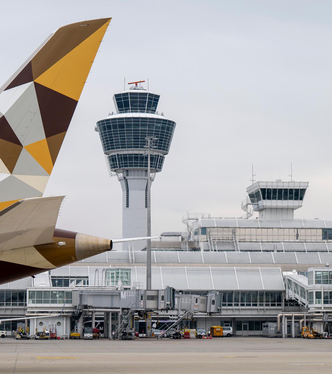 Ein Flugzeug fährt am Münchner Flughafen am Tower vorbei.