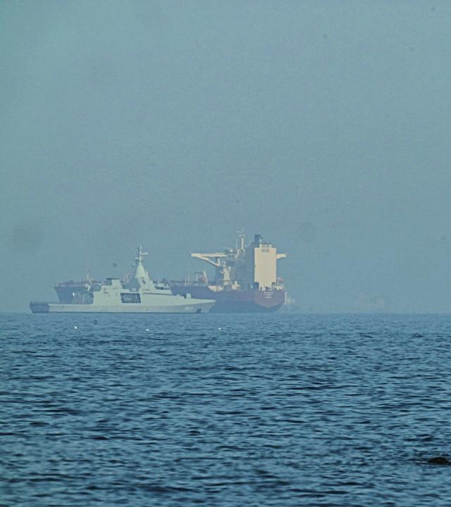 Vereinigte Arabische Emirate, Chaur Fakkan: Ein emiratisches Patrouillenboot (l) in der Nähe eines Tankers, der im Golf von Oman nahe der Straße von Hormus vor Anker liegt
