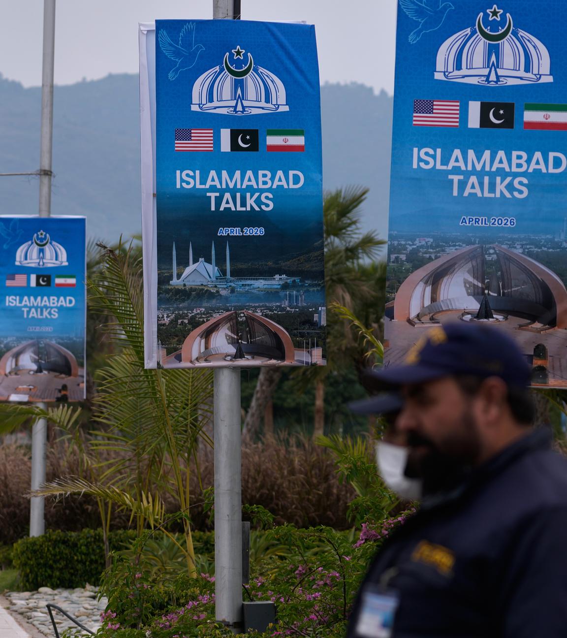 Archiv:  Sicherheitspersonal steht neben Schildern zu den Verhandlungen zwischen den USA und dem Iran vor einem Medienzentrum.