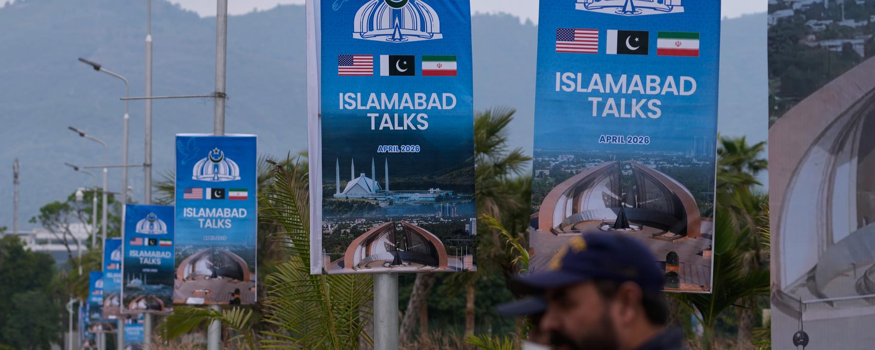 Archiv:  Sicherheitspersonal steht neben Schildern zu den Verhandlungen zwischen den USA und dem Iran vor einem Medienzentrum.