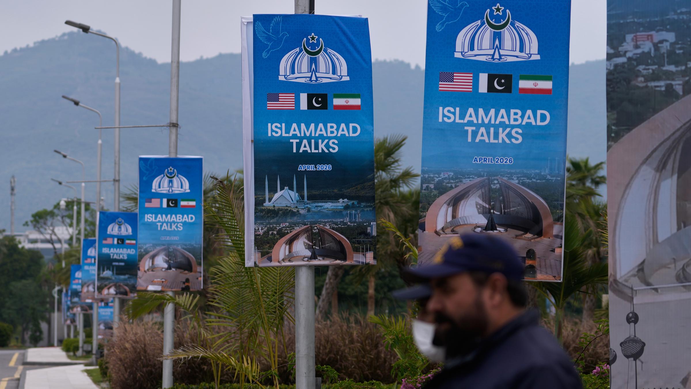 Archiv:  Sicherheitspersonal steht neben Schildern zu den Verhandlungen zwischen den USA und dem Iran vor einem Medienzentrum.