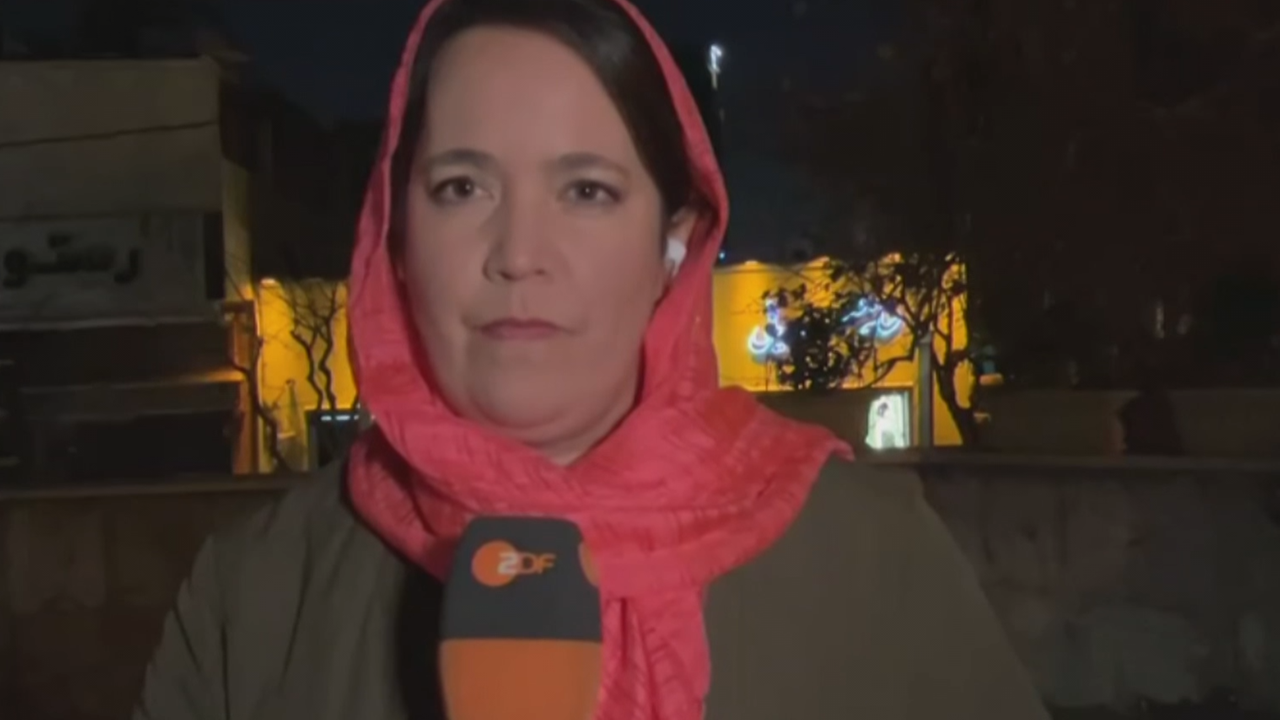 Phoebe Gaa mit Tuch um den Kopf gebunden im Mikrofon in der Hand