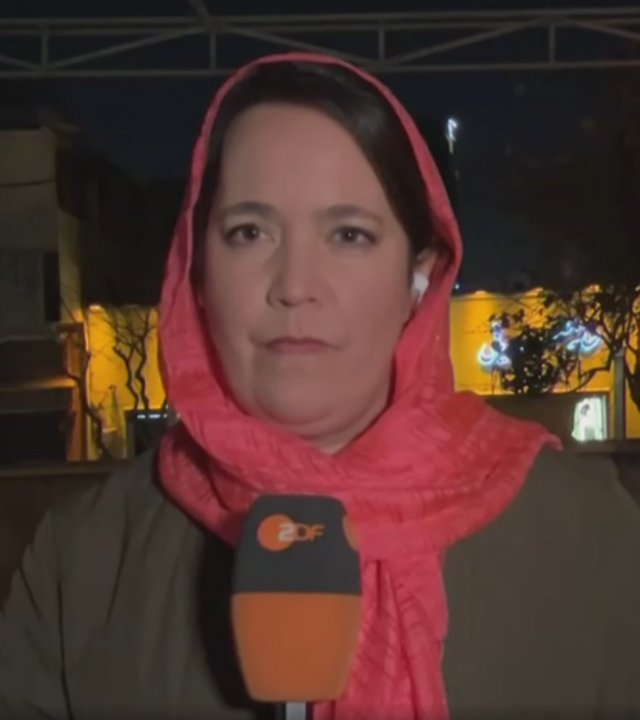 Phoebe Gaa mit Tuch um den Kopf gebunden im Mikrofon in der Hand