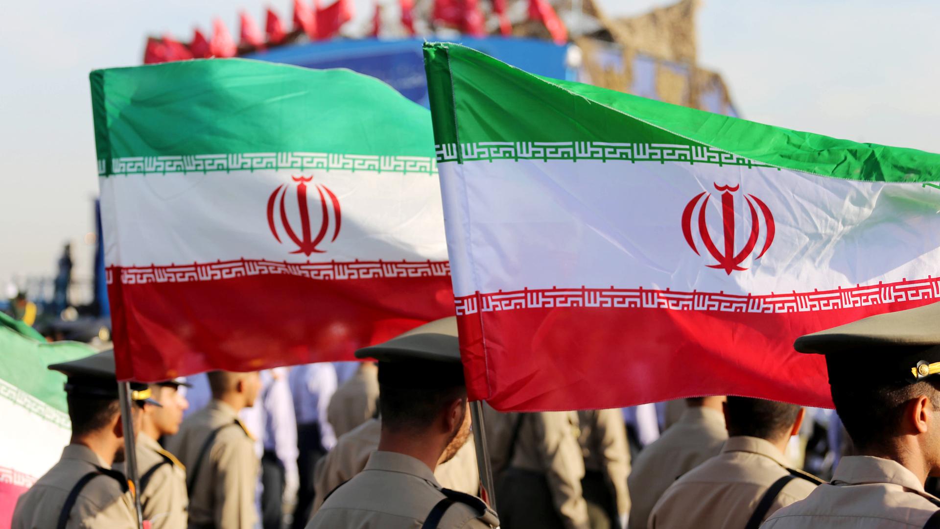 Soldaten der Armee der Islamischen Republik Iran schwenken iranische Flaggen