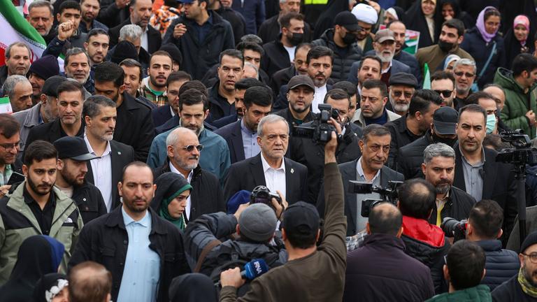 Irans Präsident Masoud Peseschkian marschiert bei einer Kundgebung zum Gedenken an den Jahrestag der Islamischen Revolution.
