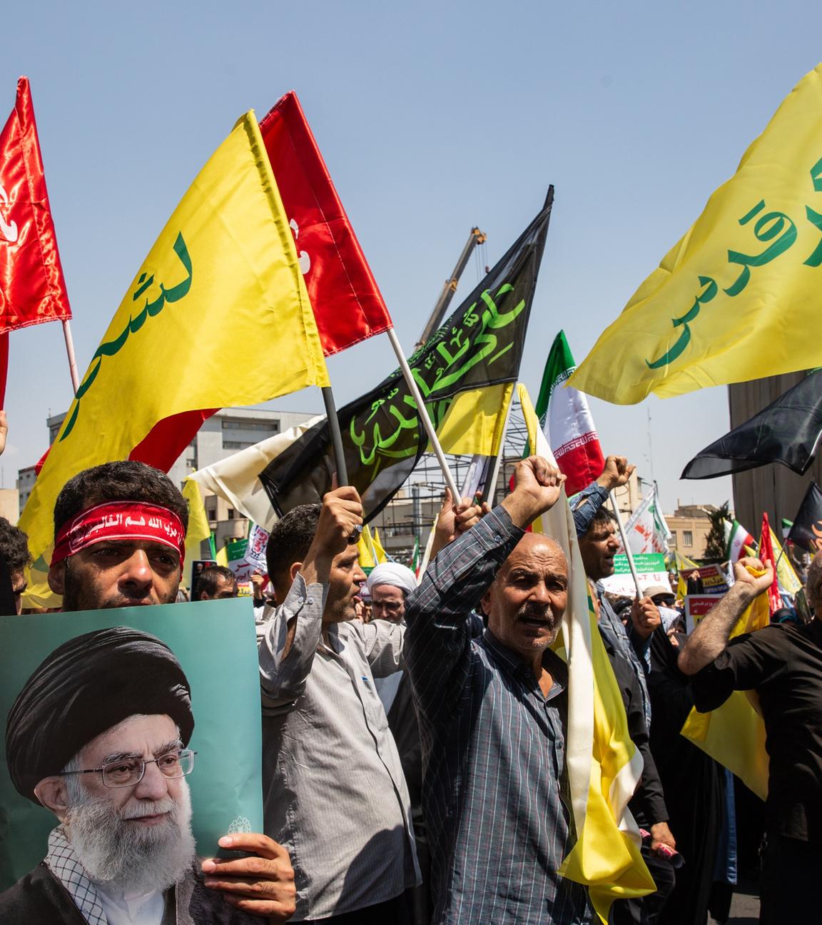 Männer demonstrieren mit iranischen Flaggen