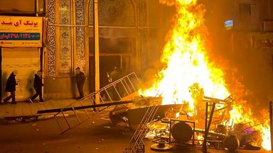 Flammen steigen am 10. Januar 2026 aus brennenden Trümmern mitten auf einer Straße in Gorgan auf.
