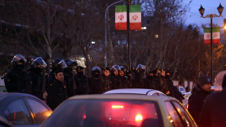 Iranische Bereitschaftspolizei steht Wache, während Studenten vor der britischen Botschaft in Teheran protestieren. 