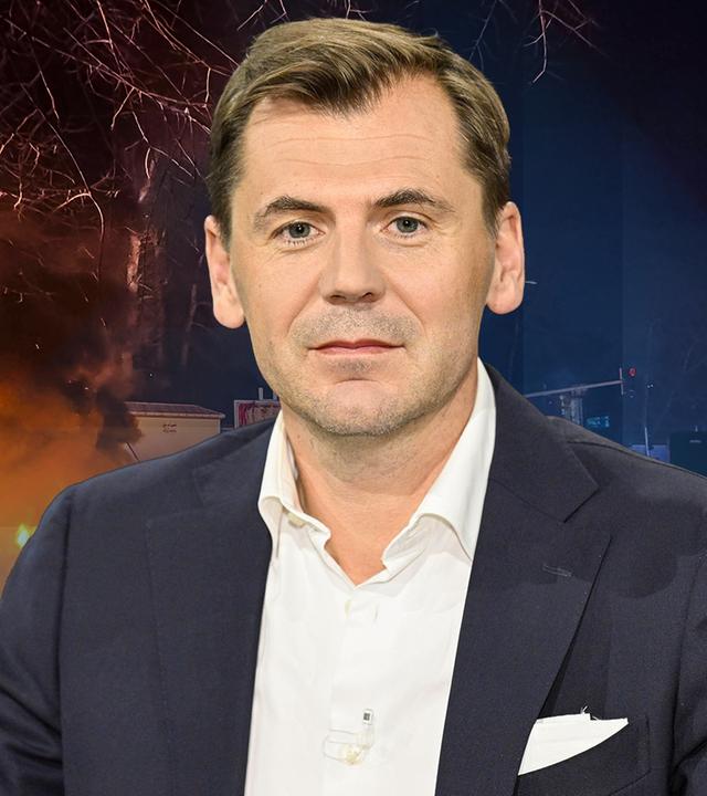 Nahost-Experte Daniel Gerlach vor einem Bild der Proteste im Iran.