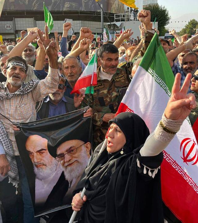 Protestors carry Iranian national flags and a poster of the late revolutionary founder Ayatollah Khomeini, left, and Supreme Leader Ayatollah Ali Khamenei, while chanting anti U.S. and Israel slogans after the attacks on nuclear sites in Iran
