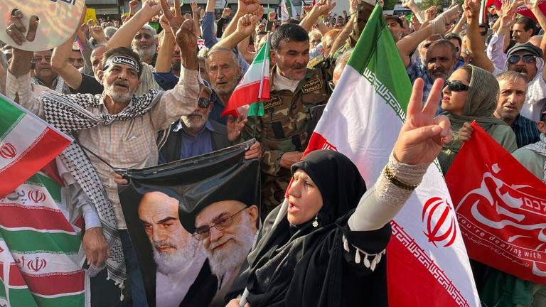 Protestors carry Iranian national flags and a poster of the late revolutionary founder Ayatollah Khomeini, left, and Supreme Leader Ayatollah Ali Khamenei, while chanting anti U.S. and Israel slogans after the attacks on nuclear sites in Iran