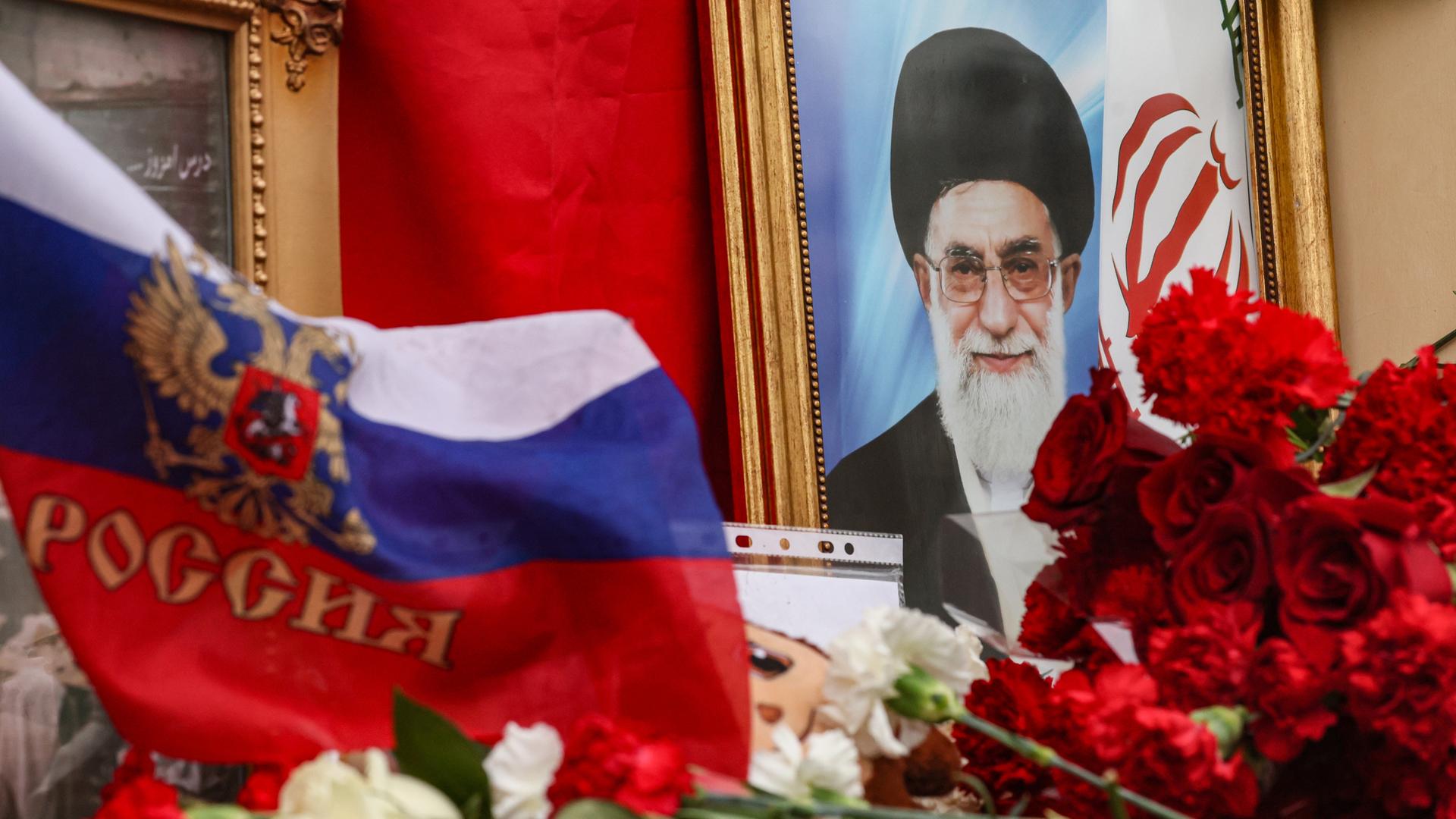 Vor der iranischen Botschaft in Moskau liegen Blumen und die russische Flagge vor dem Porträt des getöteten iranischen Machthabers Ajatollah Ali Chamenei.