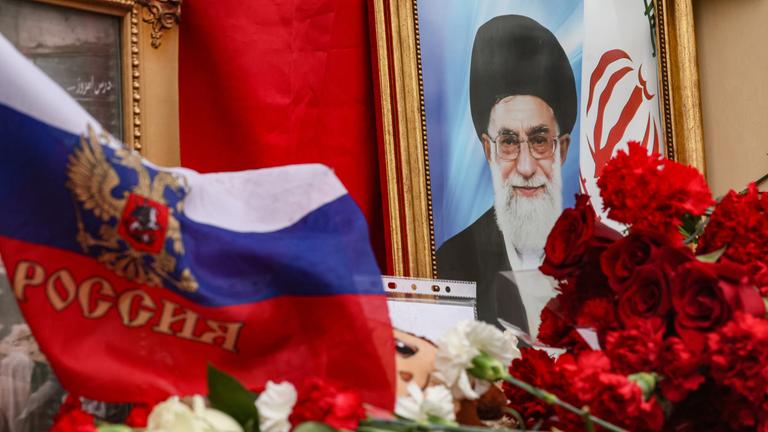 Vor der iranischen Botschaft in Moskau liegen Blumen und die russische Flagge vor dem Porträt des getöteten iranischen Machthabers Ajatollah Ali Chamenei.