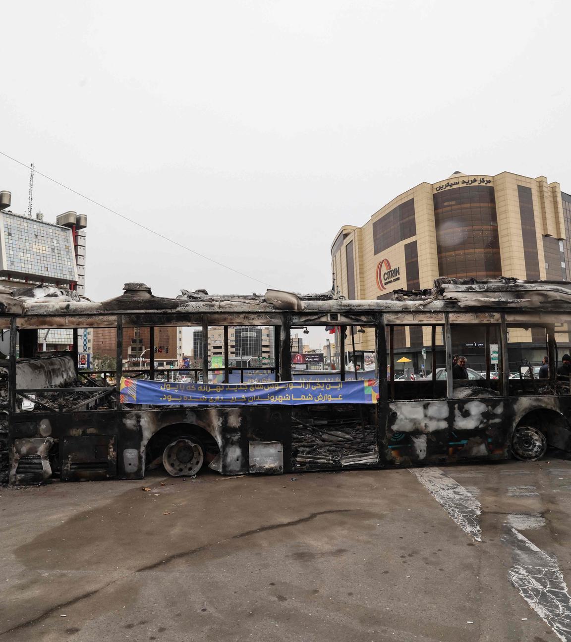 Ein Foto zeigt das Wrack eines verbrannten Busses 