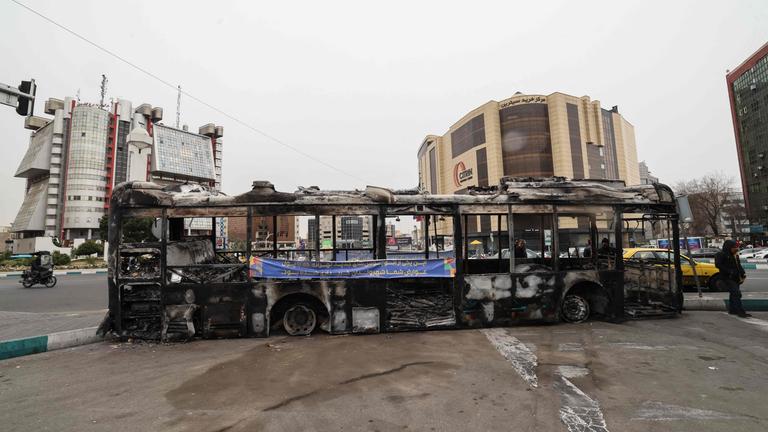 Ein Foto zeigt das Wrack eines verbrannten Busses 