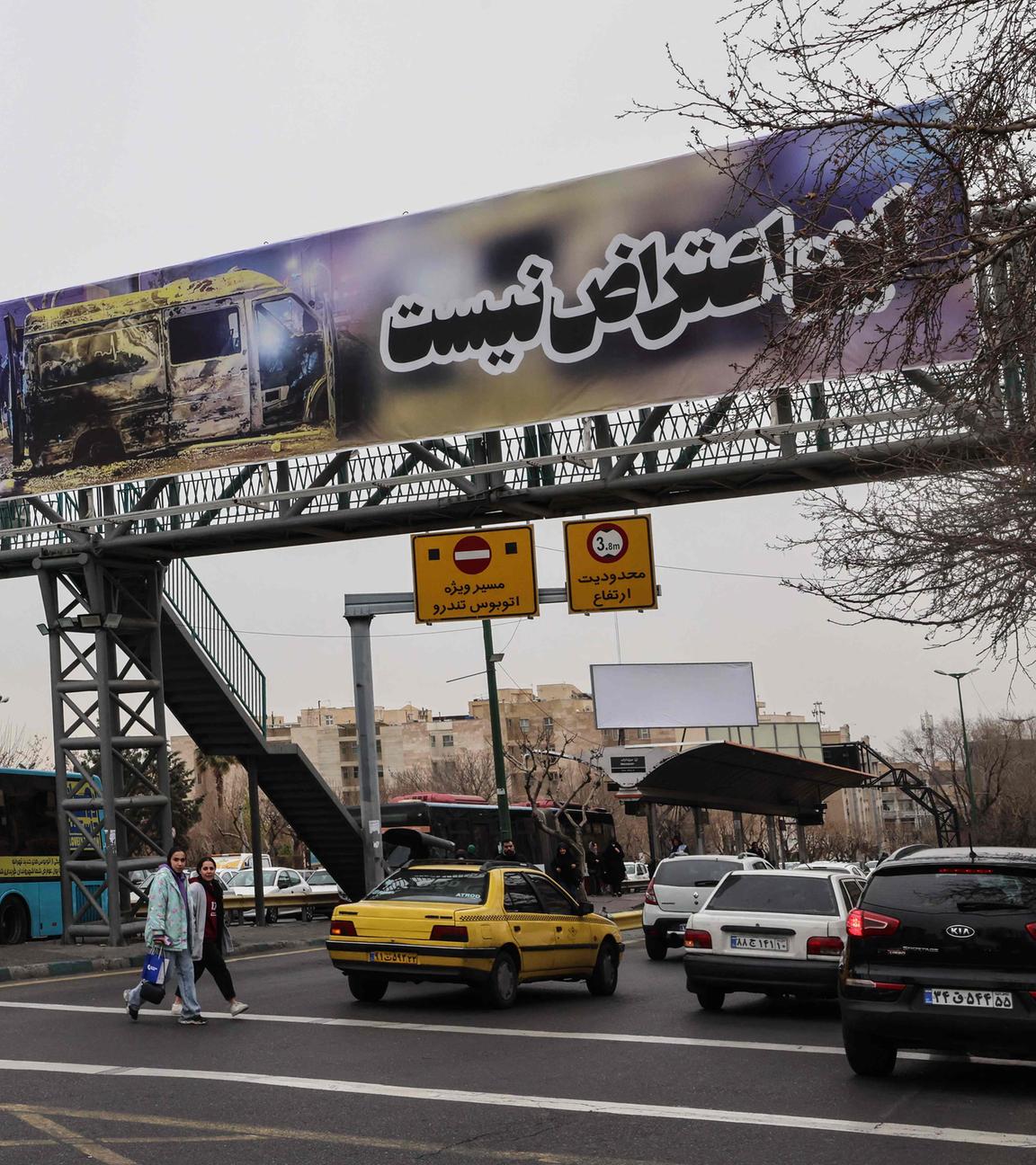 Pendler fahren am 15. Januar 2026 in Teheran unter einem Banner mit der Aufschrift "Dies ist kein Protest".