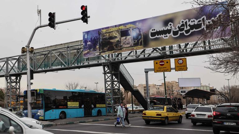 Pendler fahren am 15. Januar 2026 in Teheran unter einem Banner mit der Aufschrift "Dies ist kein Protest".