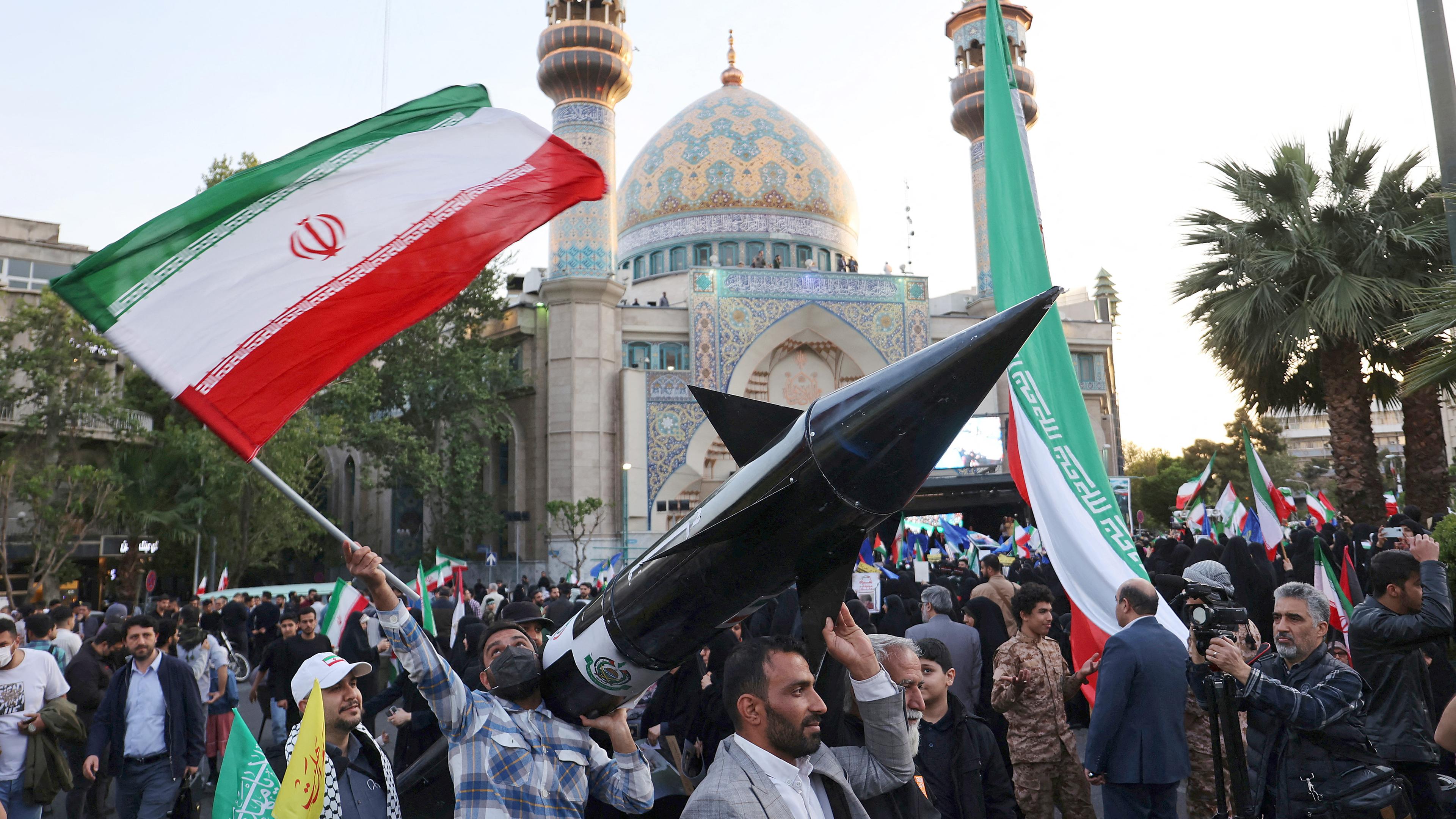 Iraner tragen ein Modell einer Rakete während einer Feier nach dem Angriff der IRGC auf Israel in Teheran (Iran), aufgenommen am 15.04.2024