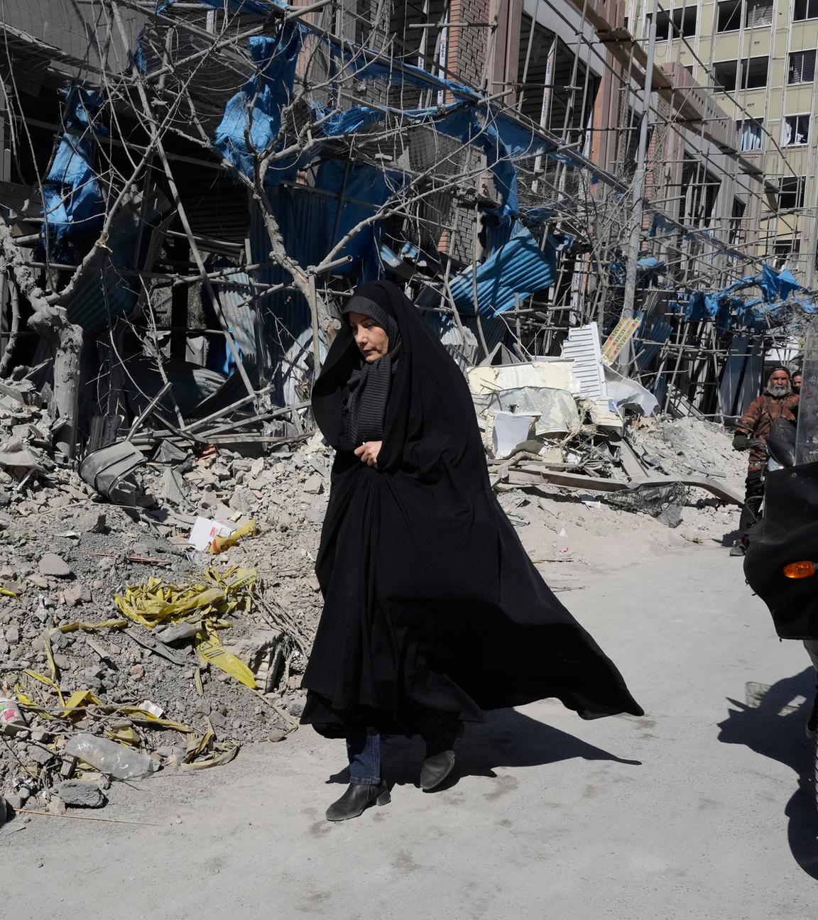 Iran, Teheran: Eine Frau geht an einer zerstörten Polizeistation vorbei