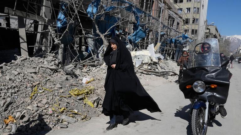 Iran, Teheran: Eine Frau geht an einer zerstörten Polizeistation vorbei