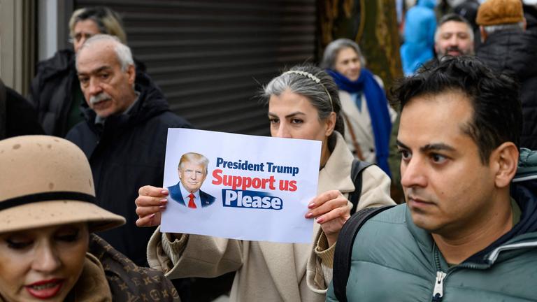 Menschen protesiteren vor dem iranischen Konsulat in Istanbul. Auf einem Bild ist US-Präsident Trump abgebildet mit der Aufschrift "President Trump Support us please".
