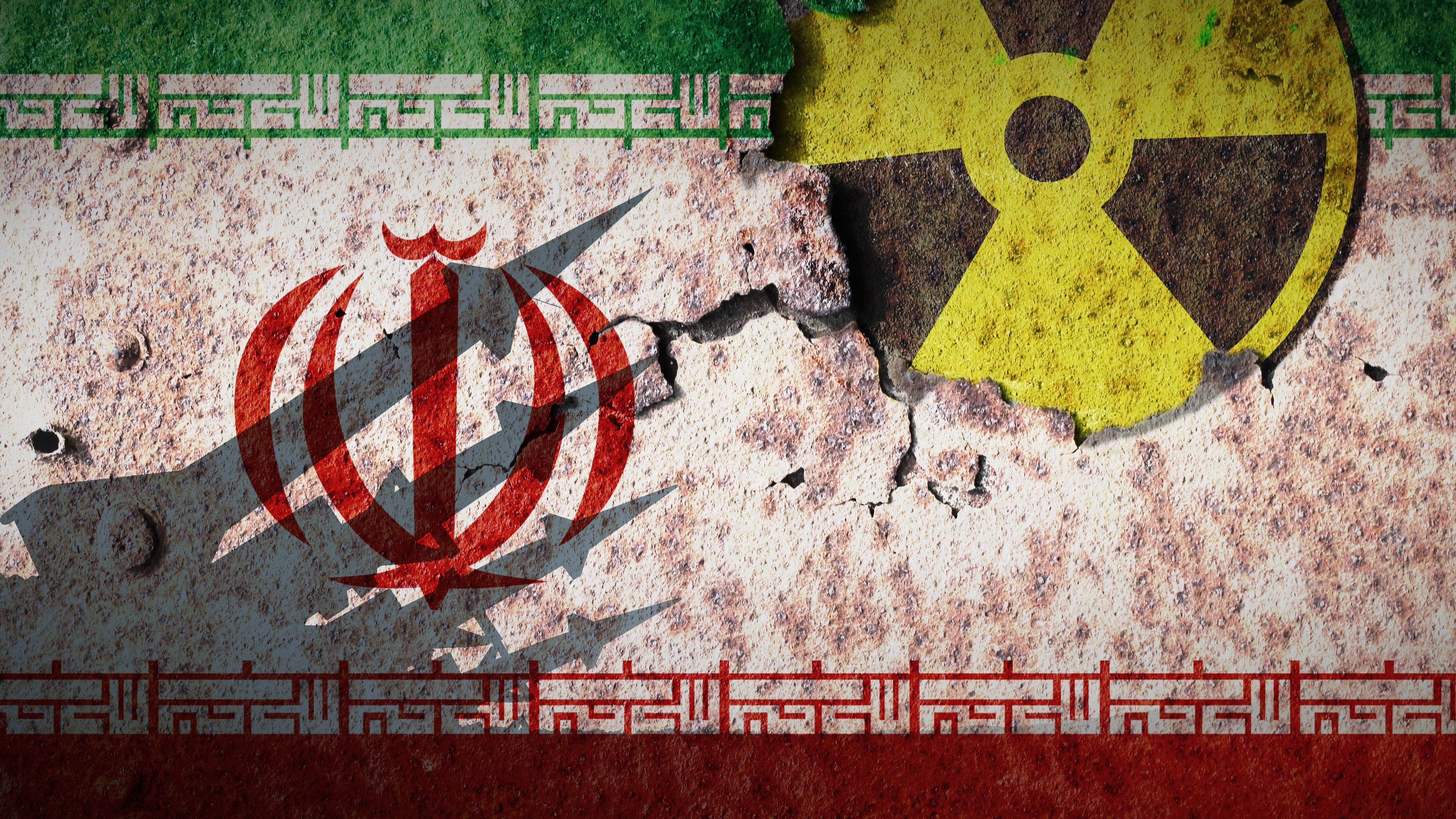 Montage: Die Flagge des Iran auf einer Wand, rechts dazu das Zeichen für Radioaktivität. Als Schatten auf der Wand mehrere militärische Raketen.